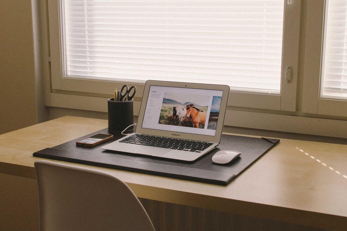 Guide on how to make money writing a book A person sitting at a desk with a laptop and a notebook, illustrating how to make money writing a book.